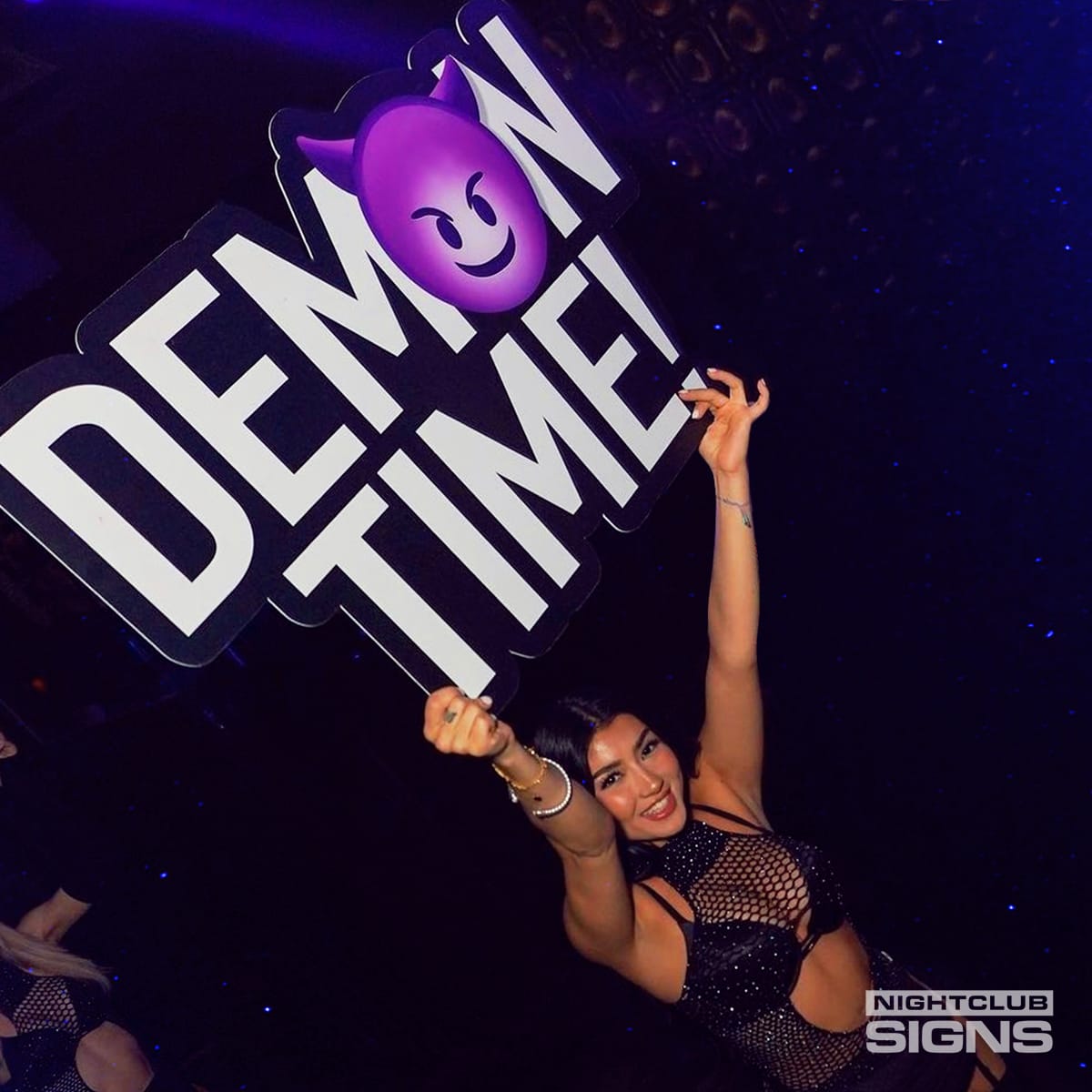 Bottle girl holding the Demon Time bottle service sign in a nightclub — high-energy VIP presentation prop