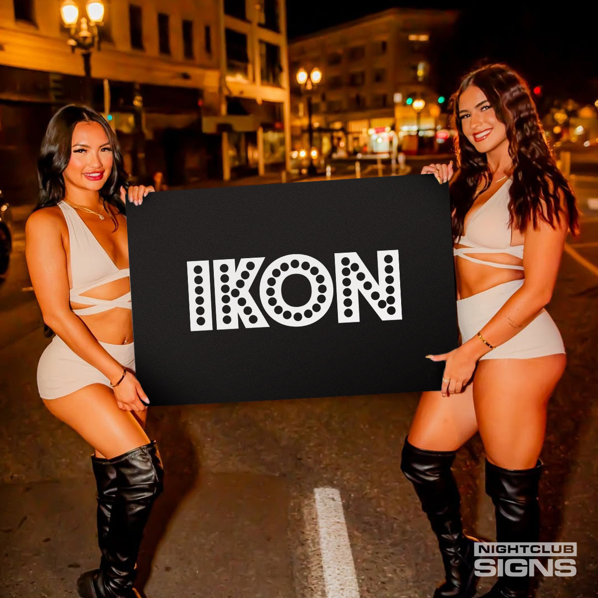 two bottle servers holding a nightclub sign