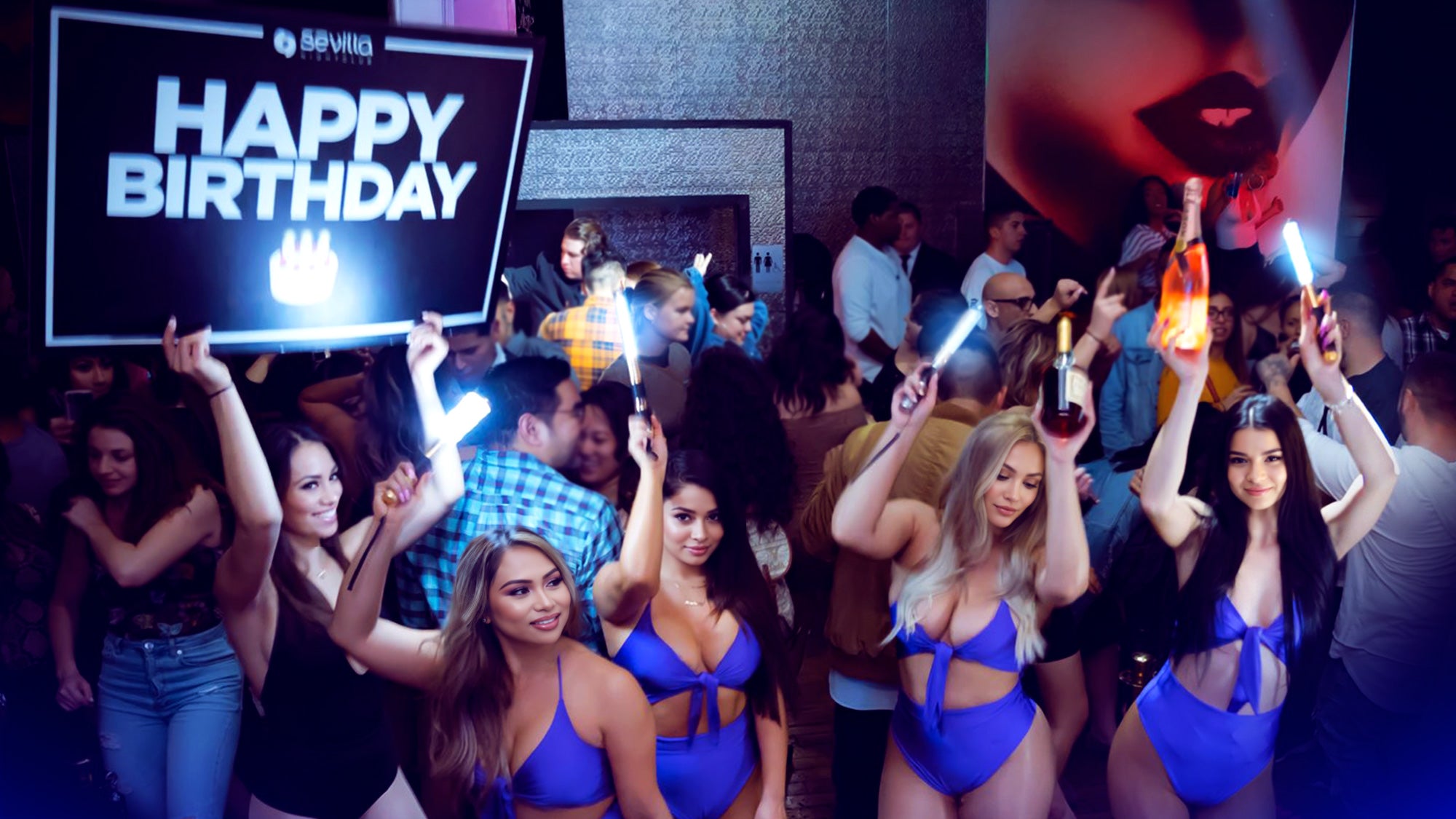 bottle girls holding up led bottle sparklers with champagne in a nightclub doing a bottle service presentation